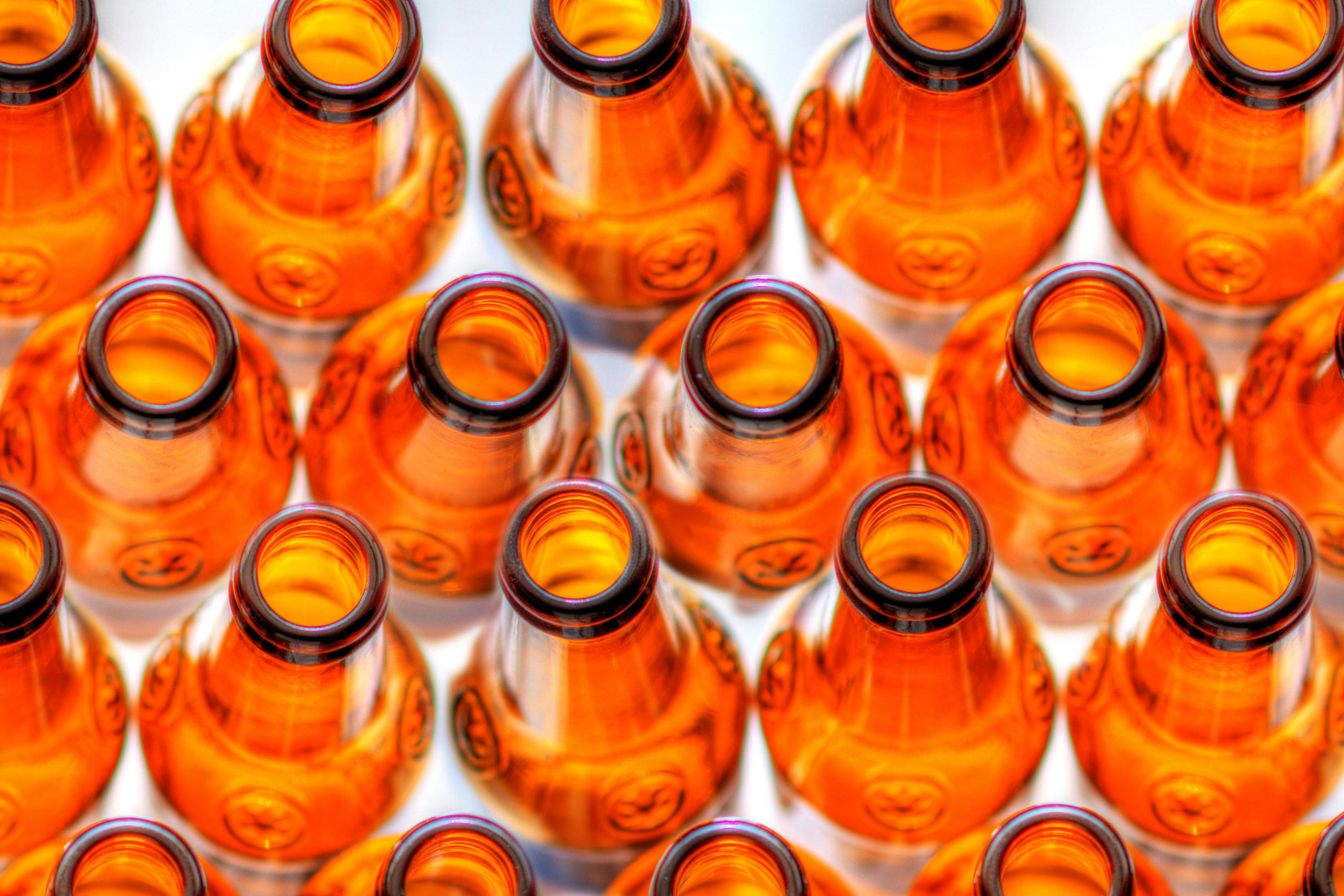 What is the proper way to open a foil-topped bottle of beer?